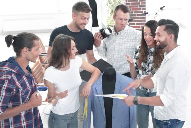 Grup tasarımcıların yeni modelleri erkek giyim tartışıyor.