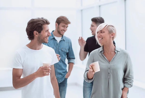 Mitarbeiter mit Kaffeegläsern gehen durch den Flur des Büros — Stockfoto