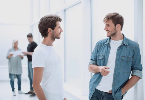 Zwei Kollegen reden im Stehen auf dem Büroflur — Stockfoto