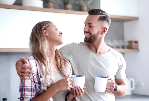 Unga par dricka kaffe stående i köket — Stockfoto