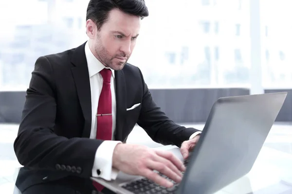 Üzletember gépel egy laptopon, ül az asztalánál — Stock Fotó