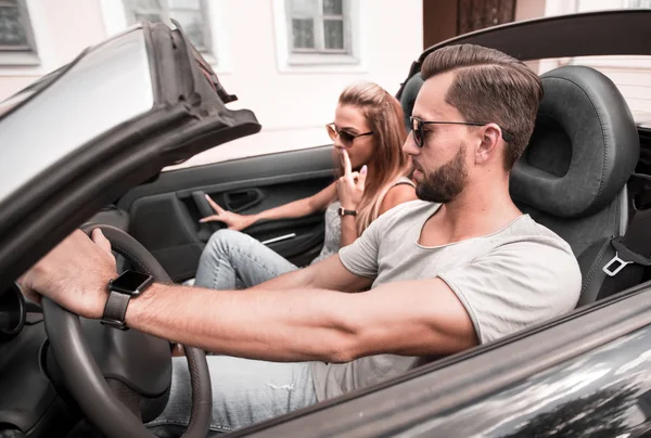 Liebespaar fährt im Cabrio auf einer Stadtstraße — Stockfoto