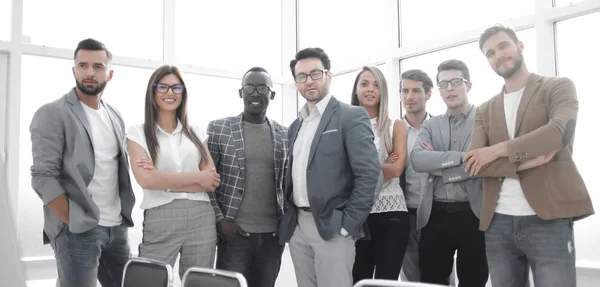 Equipe de negócios feliz em pé no escritório brilhante. — Fotografia de Stock