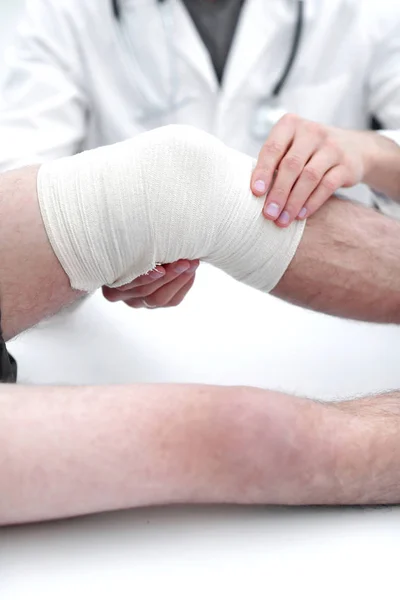 Traumatologista, aplicando uma bandagem no joelho — Fotografia de Stock