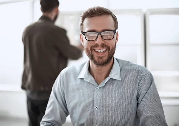 Amigable hombre de negocios sentado en su escritorio — Foto de Stock