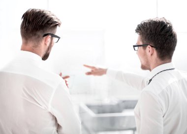 arka view.business meslektaşları ayakta parlak bir ofiste konuşmak