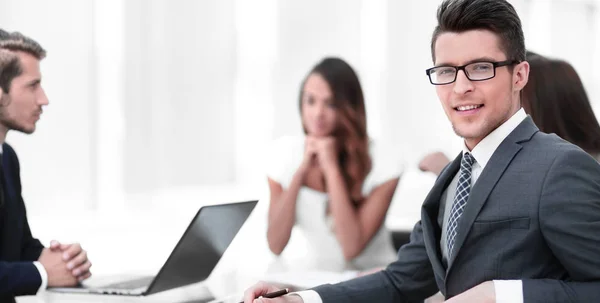 Joven hombre de negocios con su equipo de negocios sentado en su escritorio —  Fotos de Stock