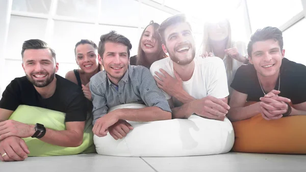 group of young people lying on the floor and smiling