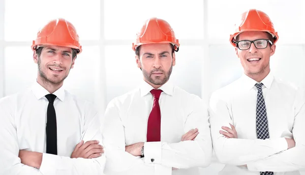 Cerrar. Tres hombres de negocios seguros en cascos de protección —  Fotos de Stock