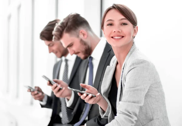 Empleados jóvenes utilizando sus teléfonos inteligentes — Foto de Stock