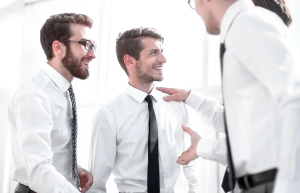 Empleados sonrientes estrechando las manos en la oficina — Foto de Stock