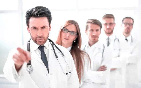 Přísné lékař, ukazuje na sebe, stojící na pracovišti — Stock fotografie