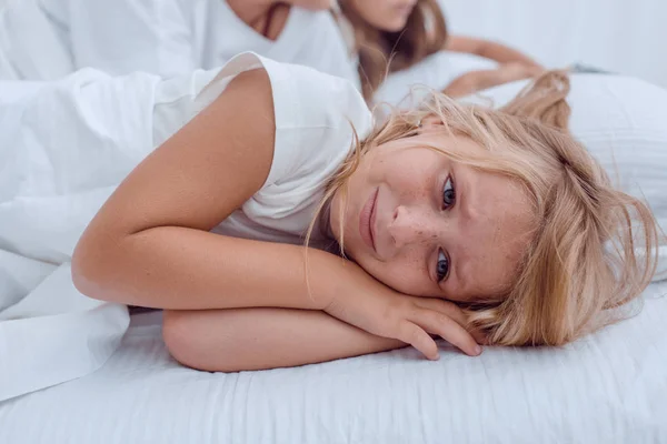 Hübsches kleines Mädchen liegt auf dem Bett ihrer Eltern — Stockfoto
