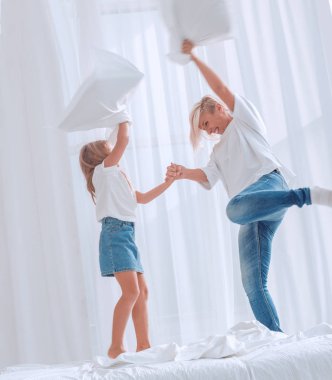 yakın kapatın. anne ve kızı yatakta bir yastık kavga var