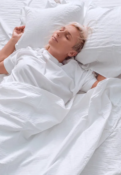 Közelről. aranyos fiatal nő elalszik az ágyában — Stock Fotó