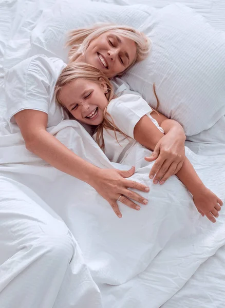 Fecha. mãe feliz com sua filha acordando juntos — Fotografia de Stock