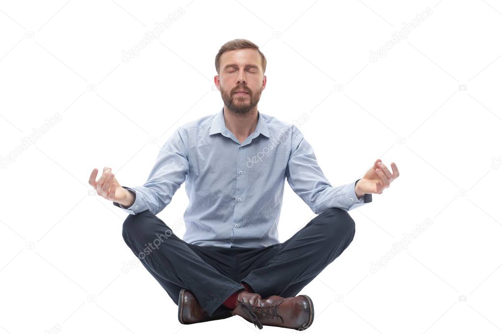 young businessman meditates sitting on the floor
