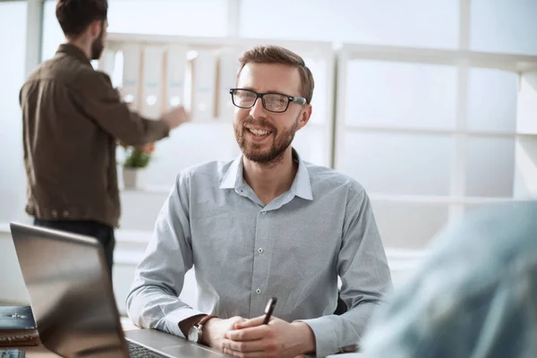 Nahaufnahme. Lächelnder Geschäftsmann am Schreibtisch — Stockfoto