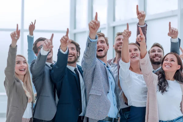 Groep gelukkige jonge zakenmensen die naar boven wijzen — Stockfoto