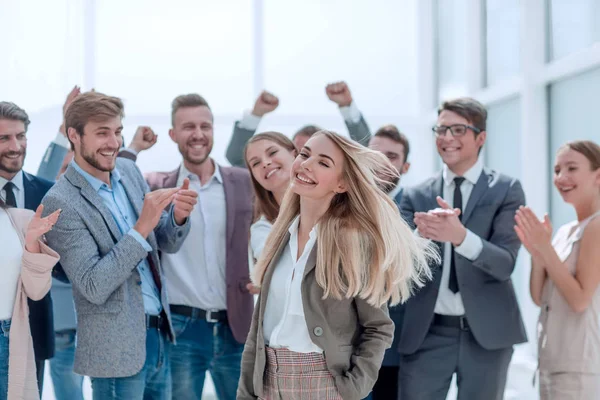 Gelukkige jonge vrouw die voor haar jubilerende collega's staat — Stockfoto