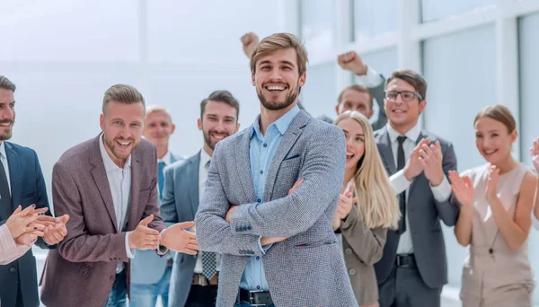 Крупний план. веселі співробітники компанії аплодують своєму колезі . — стокове фото