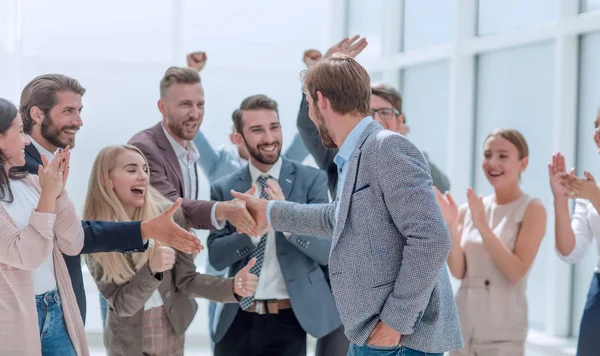 corporate group of employees congratulating their colleague.