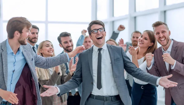 Pria bisnis bahagia berdiri di antara rekan-rekannya. — Stok Foto