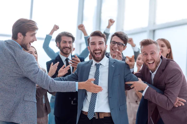 Close up. happy business team hugging their leader — Stock Photo, Image