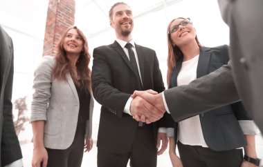 İş adamları konferans odasında el sıkışıyor.