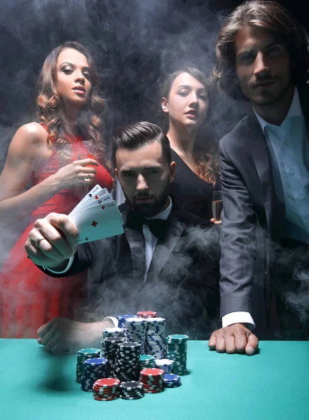 Concentrated men and women playing poker in casino — Stock Photo, Image