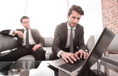 işadamı gerekli bilgileri bulmak için bir dizüstü bilgisayar kullanır.