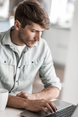 yakın kapatın. dairesinden bir dizüstü bilgisayar üzerinde çalışan genç bir adam