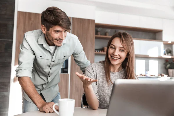 Jovem casal discutir algo sentado na frente de um laptop — Fotografia de Stock