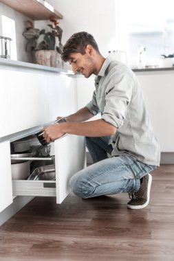 mutfak masasından tabak ları alarak çekici adam