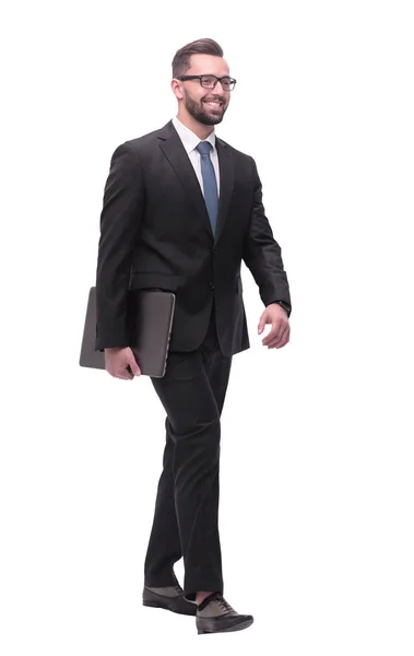Вид сбоку. улыбающийся бизнесмен с ноутбуком шагает вперед — стоковое фото