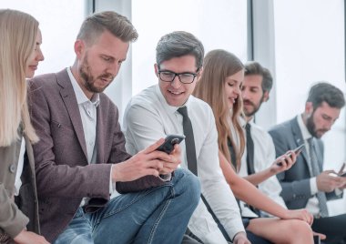 Genç çalışanlar haberleri internetten izlemek için akıllı telefonlarını kullanıyorlar.