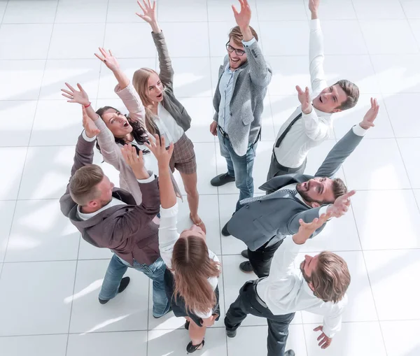 Vista superior. exitoso equipo de negocios de pie en un círculo con las manos arriba . — Foto de Stock