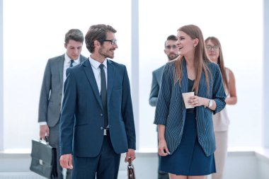 Başarılı bir iş adamı ofis koridorunda çalışanlarla konuşuyor. .