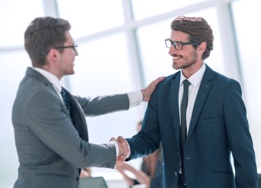 Gülümseyen iş adamları el sıkışmak için ellerini uzatıyor.