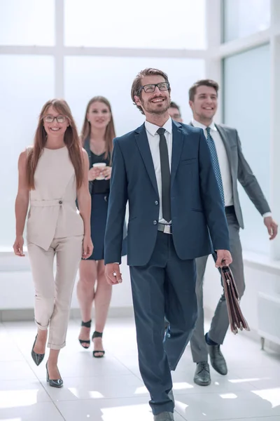 businessman walking in front of his business team