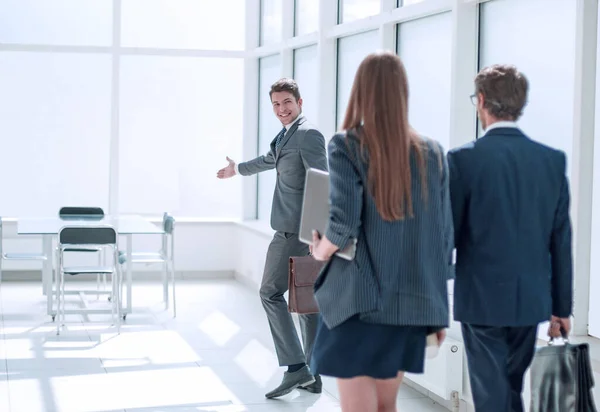 young businessman inviting employees to his new office