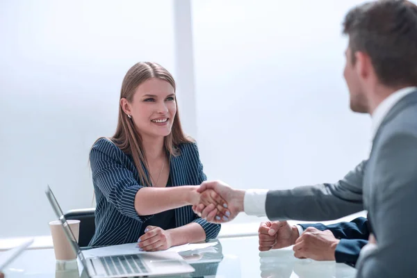 Hombre de negocios estrechando la mano con la mujer de negocios sentada en la mesa de negociaciones —  Fotos de Stock