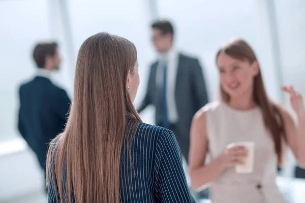 stock image businesswoman with a glass of coffee discussing something with her colleague