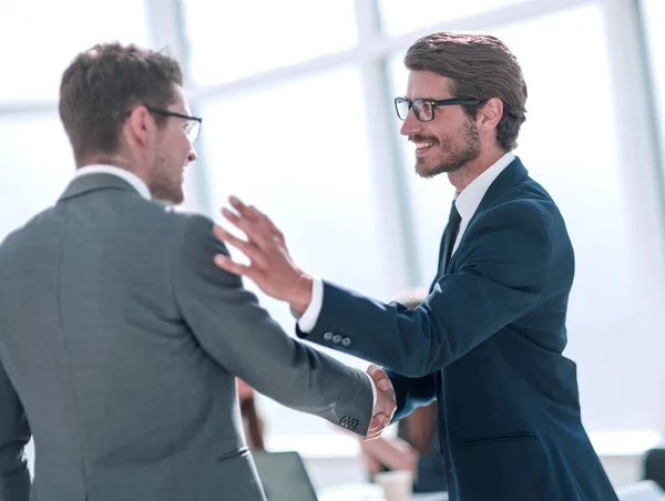 Sorridenti uomini d'affari si salutano con una stretta di mano — Foto Stock