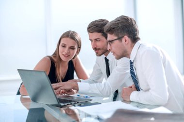 çalışanların yeni veriyi denetlemek için bir dizüstü bilgisayar kullanmak.