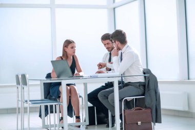 ciddi çalışanlar bir dizüstü bilgisayarda çevrimiçi bilgi tarıyor.