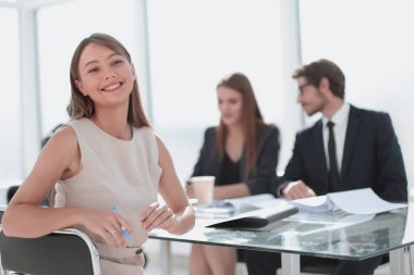 ofis masasında oturan gülümseyen iş kadını