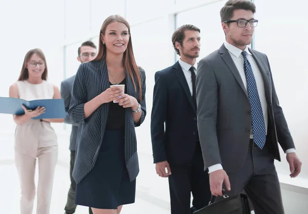 Empresários que vão ao longo do corredor do escritório durante o dia útil — Fotografia de Stock