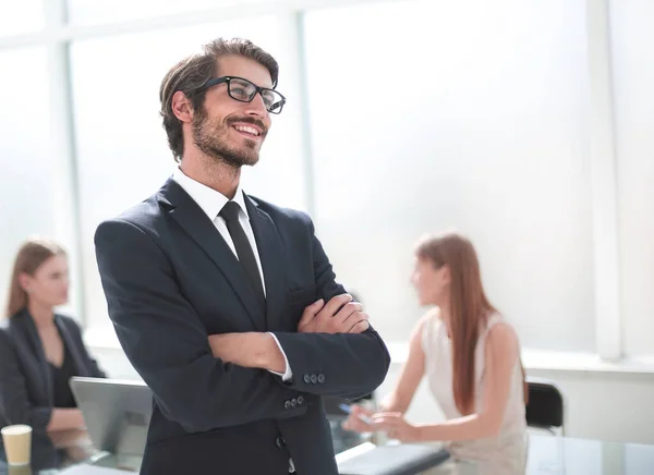 Sorridente giovane uomo d'affari in piedi nel suo ufficio — Foto Stock