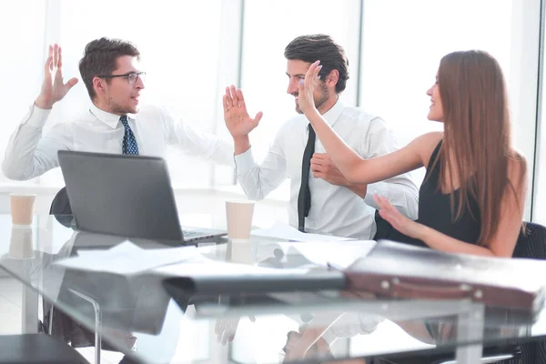 Feliz equipo de negocios sentado en el escritorio — Foto de Stock